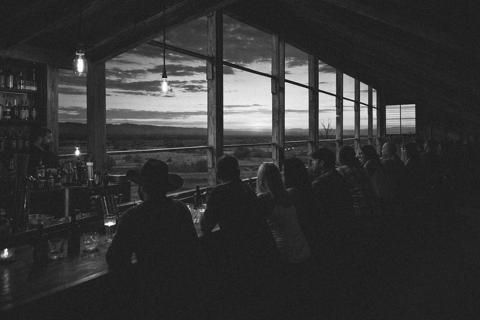 Guests gathered at the Mojave Coop bar overlooking the desert at sunset.